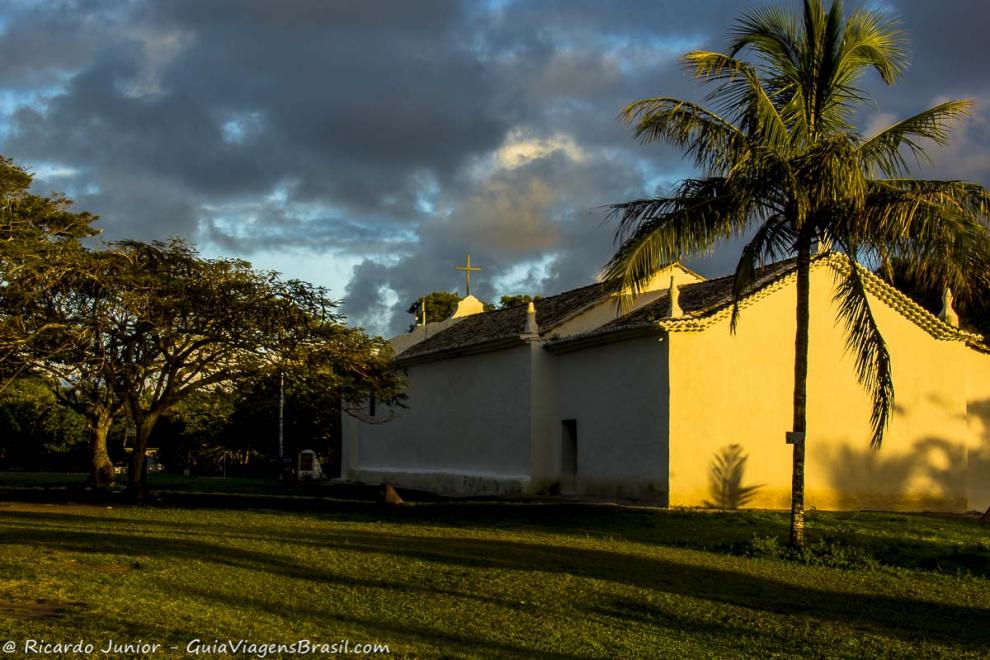 Imagem da luz do sol batendo na igreja e nas árvores na praça em Quadrado.